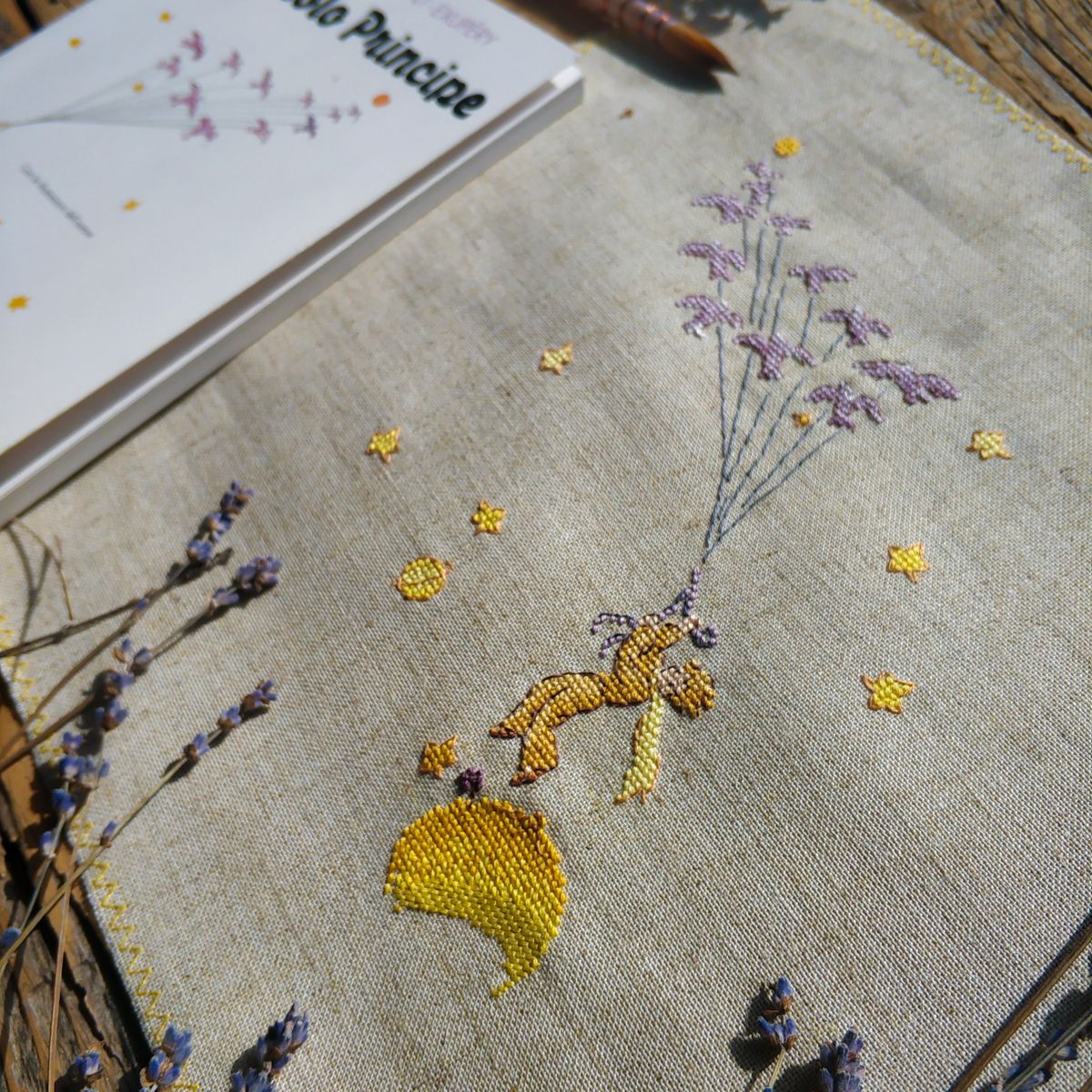 Linen sampler stitched with lavender and gold motifs
