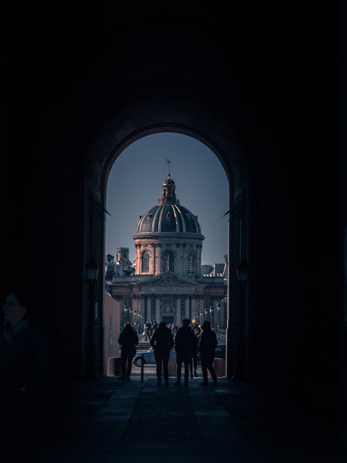 Silhouette of People Standing Across the Institute de France Building in Paris, France