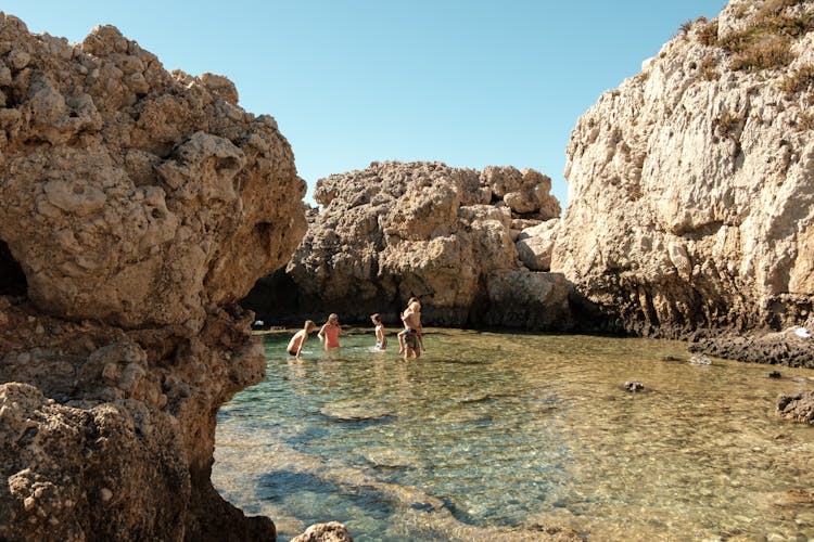 Family In Water Among Rocks