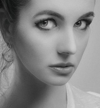 Intimate black and white portrait of a young woman with expressive eyes.