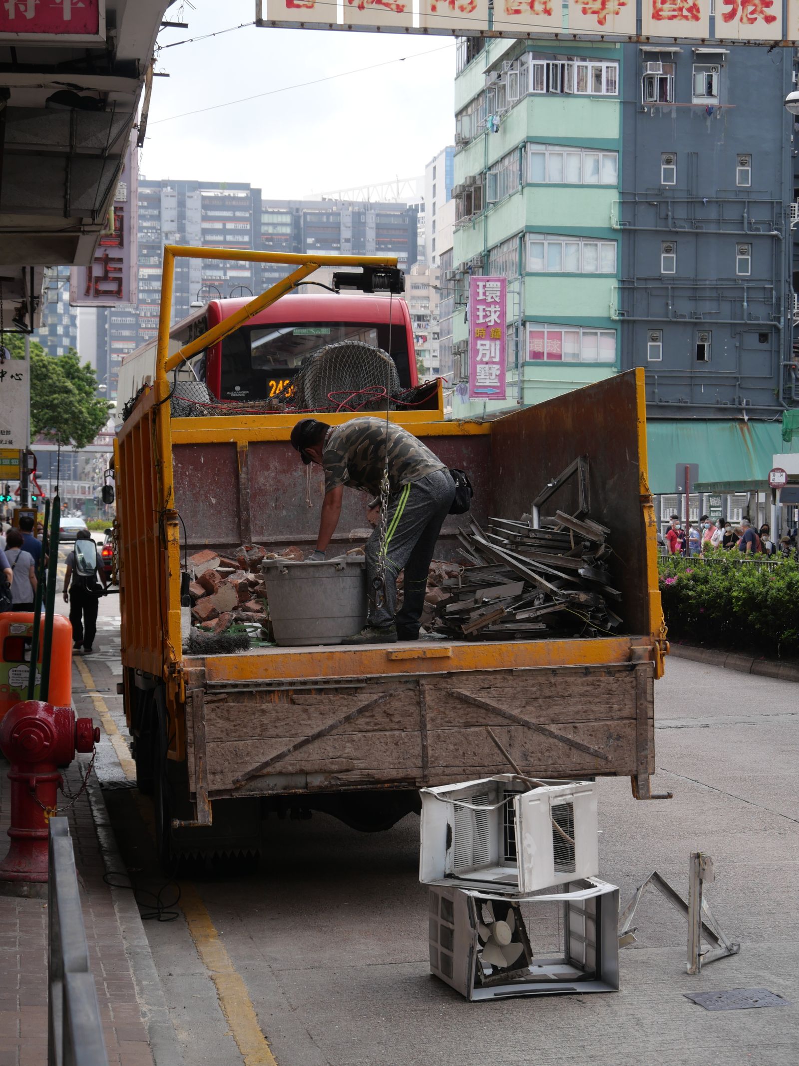 A driveway and lot piled with junk and an old vehicle before haul-off