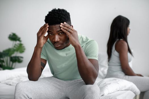 A Man Sitting on the Bed with His Hands on His Head