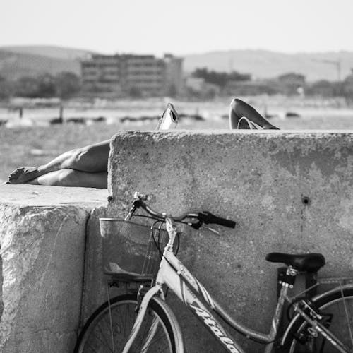 Grayscale Photo of a Bicycle Leaning on a Concrete Wall