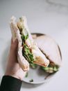 Person Holding Sandwich With Green Vegetable