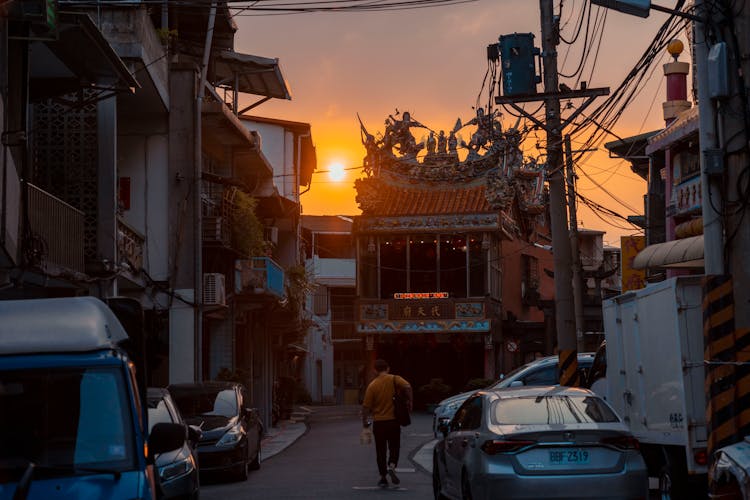 Man Walking On Street At Sunset