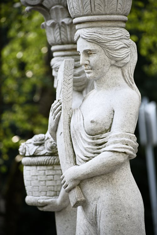 A White Concrete Statue of a Woman with her Breast Showing
