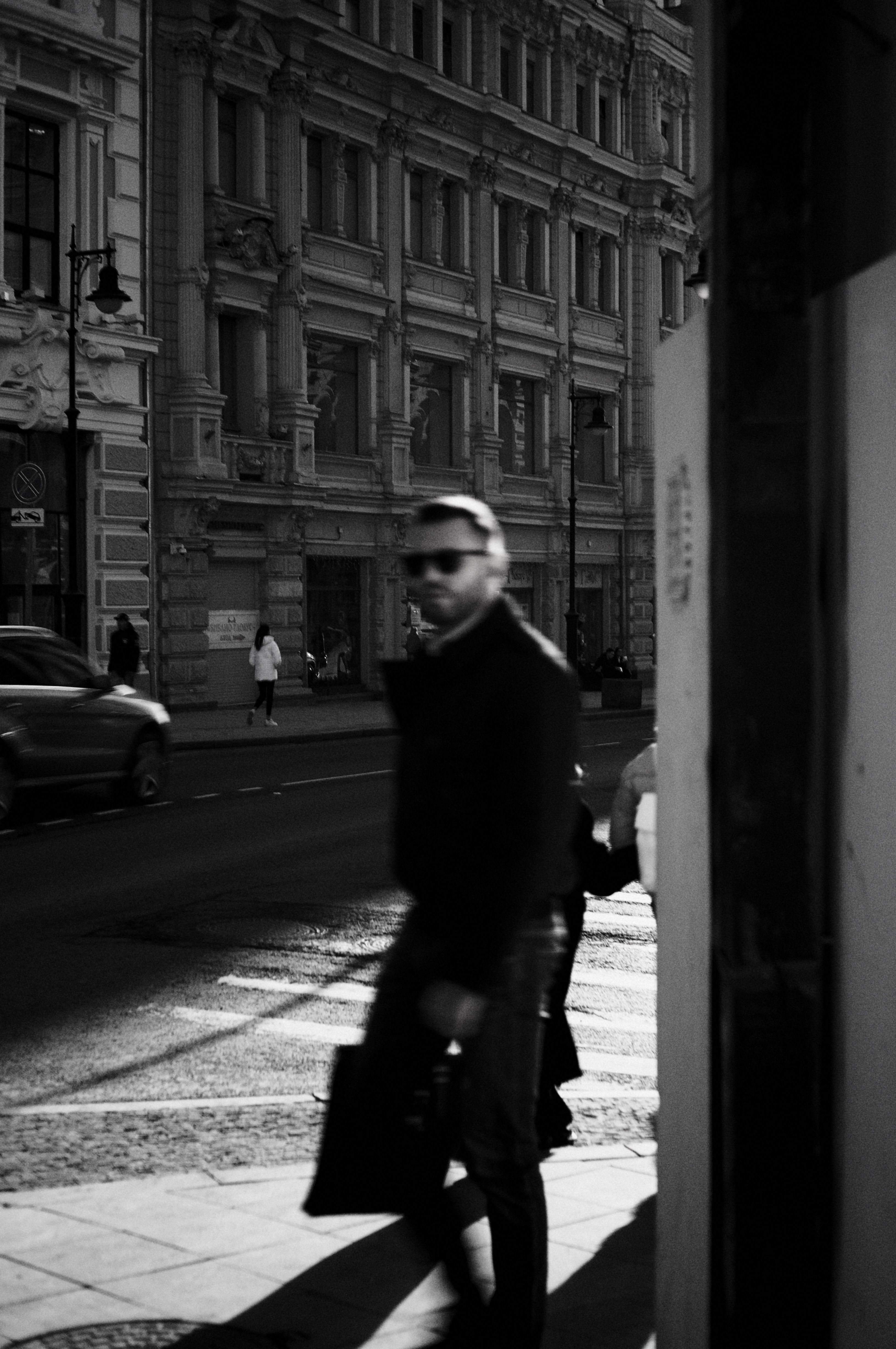 A Grayscale Photo of a Man Walking on the Street · Free Stock Photo