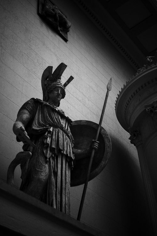 Free A captivating black and white photograph of a classical statue holding a spear and shield. Stock Photo
