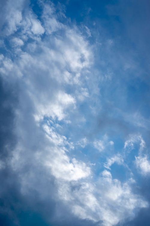 Free Beautiful blue sky with white clouds forming a dreamy and atmospheric scene. Stock Photo