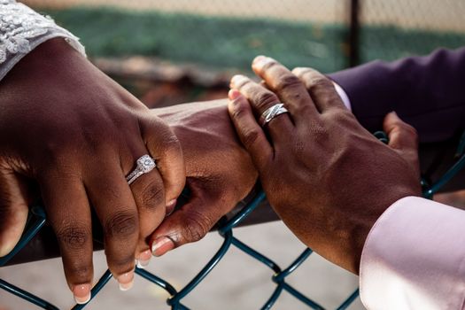 Close-up of a couple's hands with wedding rings, symbolizing love and commitment.