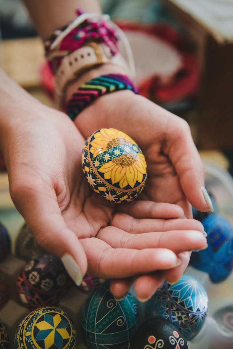 Ukrainian Sunflower Pysanky Egg On A Person's Hand