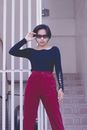 A Woman in Black Long Sleeve Shirt and Red Pants Wearing Black Sunglasses