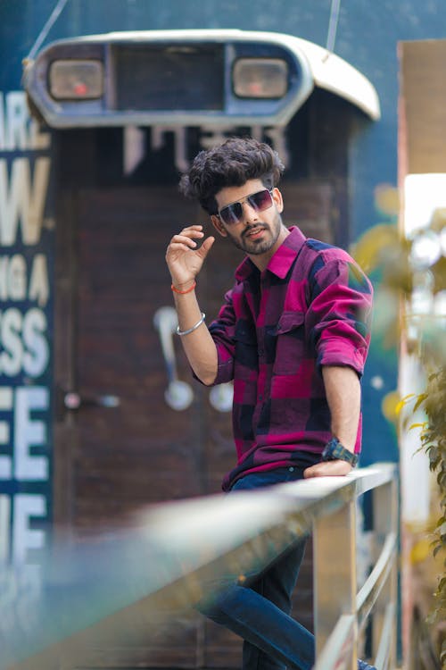 Man in Plaid Shirt Holding on a Railing