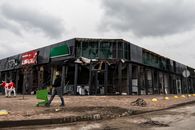 Man with shopping cart near destroyed market in Makariv, Ukraine