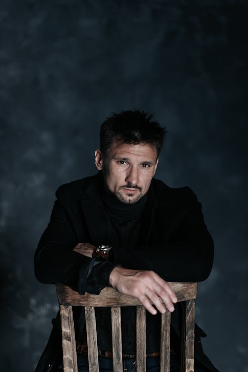 Free Man in Black Outfit Sitting on a Chair Backwards Stock Photo