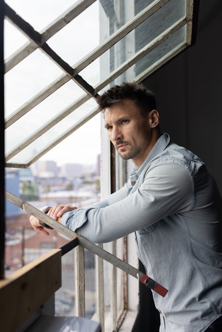 Man Looking Out Of A Loft Window