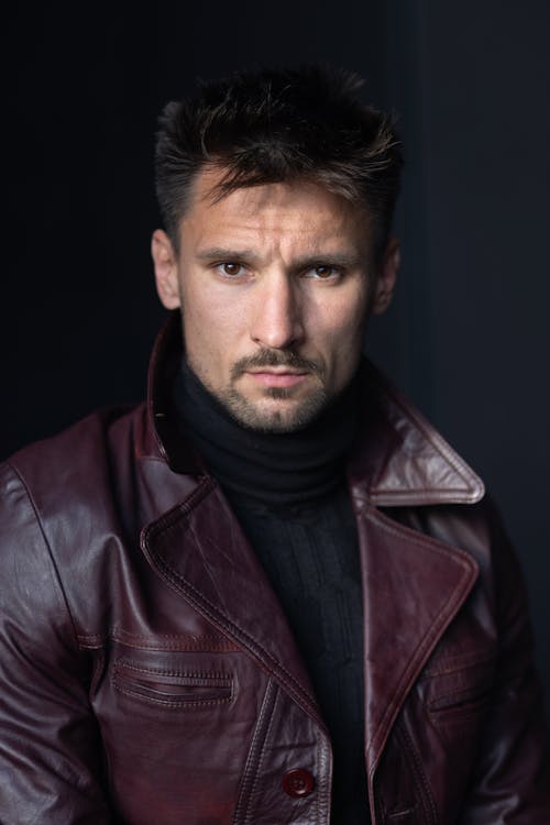 A Man in Burgundy Leather Jacket Looking with a Serious Face
