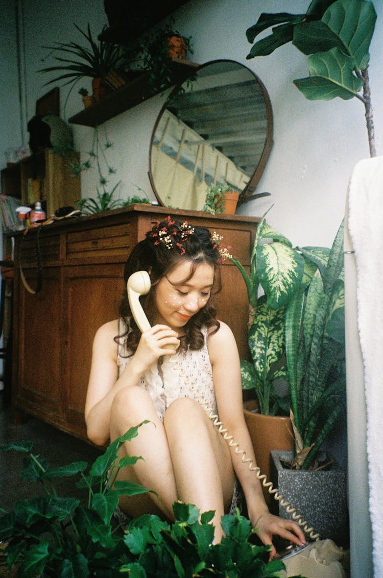 Woman Sitting On Apartment Floor Answering Phone