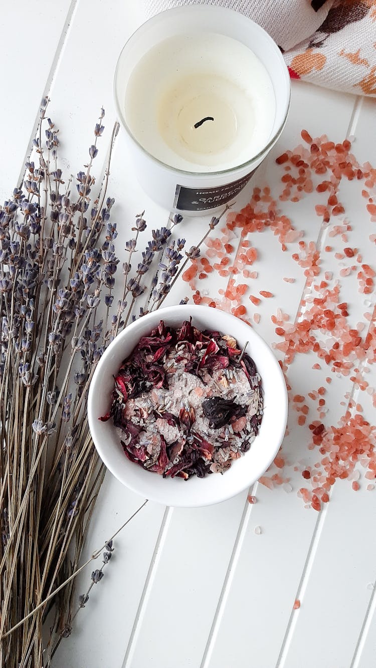 A Bowl Of Potpourri Beside A Scented Candle