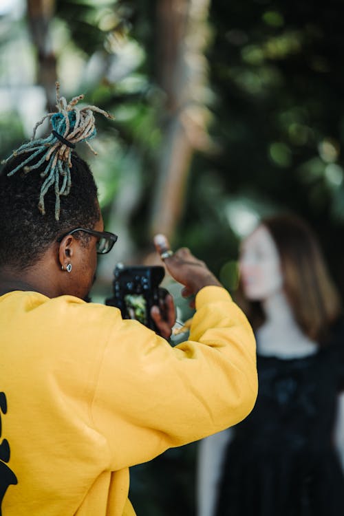 Free Man in Yellow Sweater Taking a Picture Stock Photo