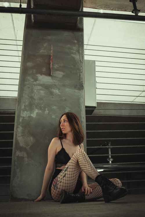 Free Stylish woman in urban outfit posing in an industrial space. Stock Photo