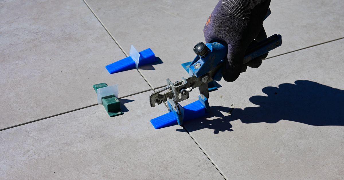Leveling Hand Hand in a Glove Using a Tile Levelling Tool · Free Stock Photo