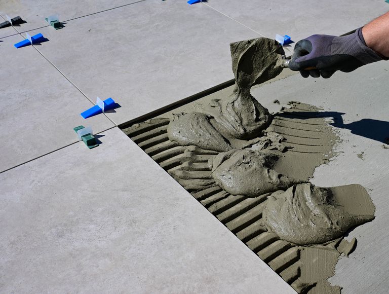 Installer spreading adhesive for luxury vinyl flooring installation