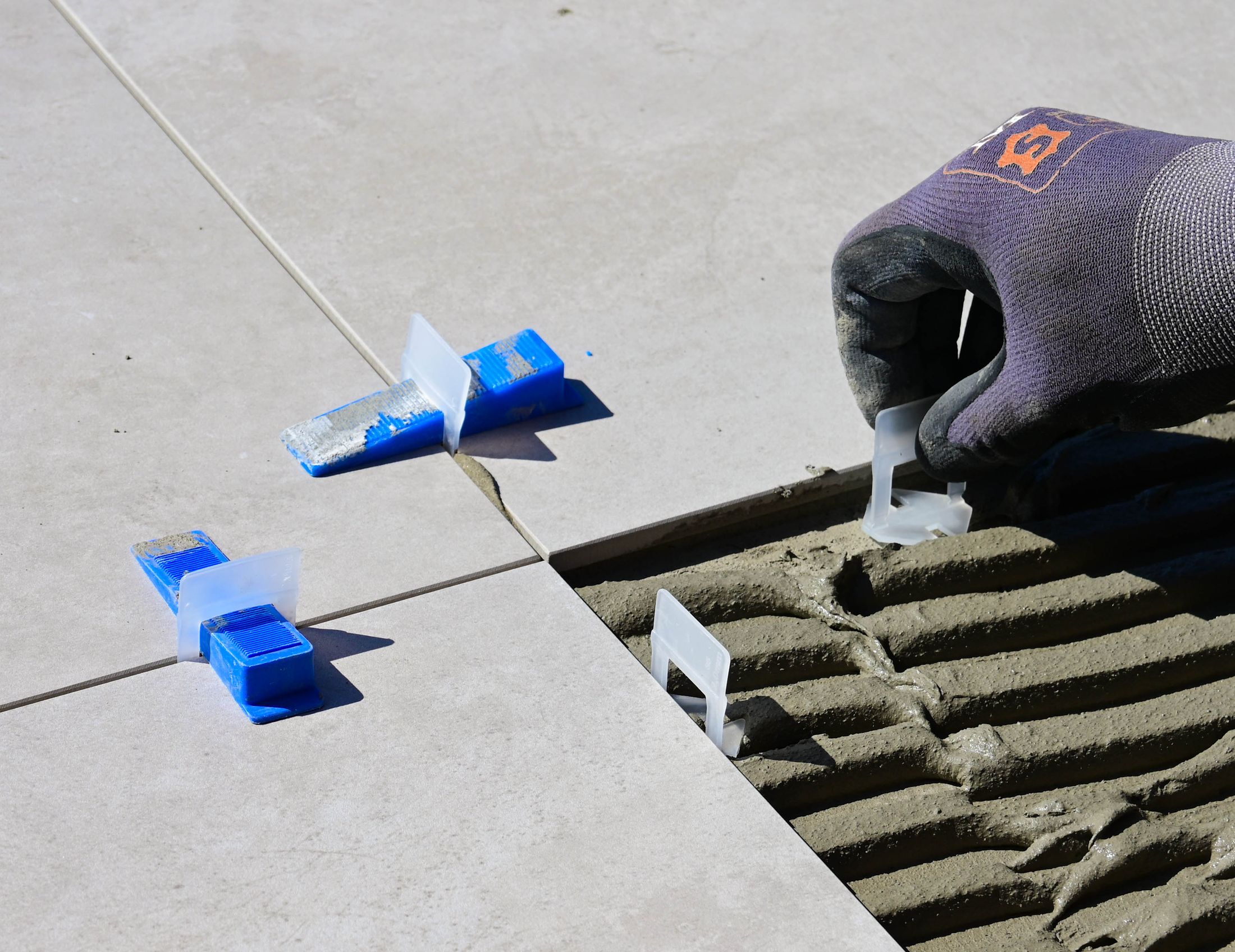 Professional tile installation using adhesive and tile levelling tools