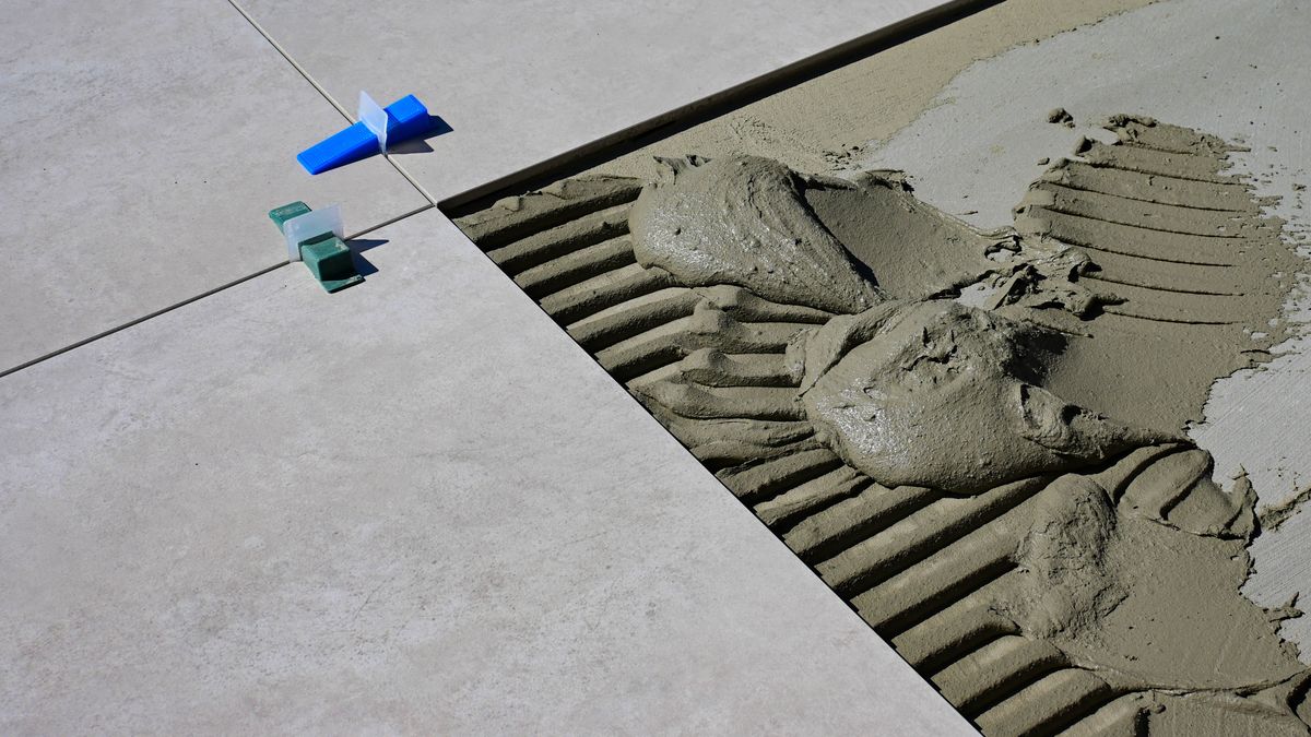 Pose de carrelage sol en rénovation avec outils de chantier