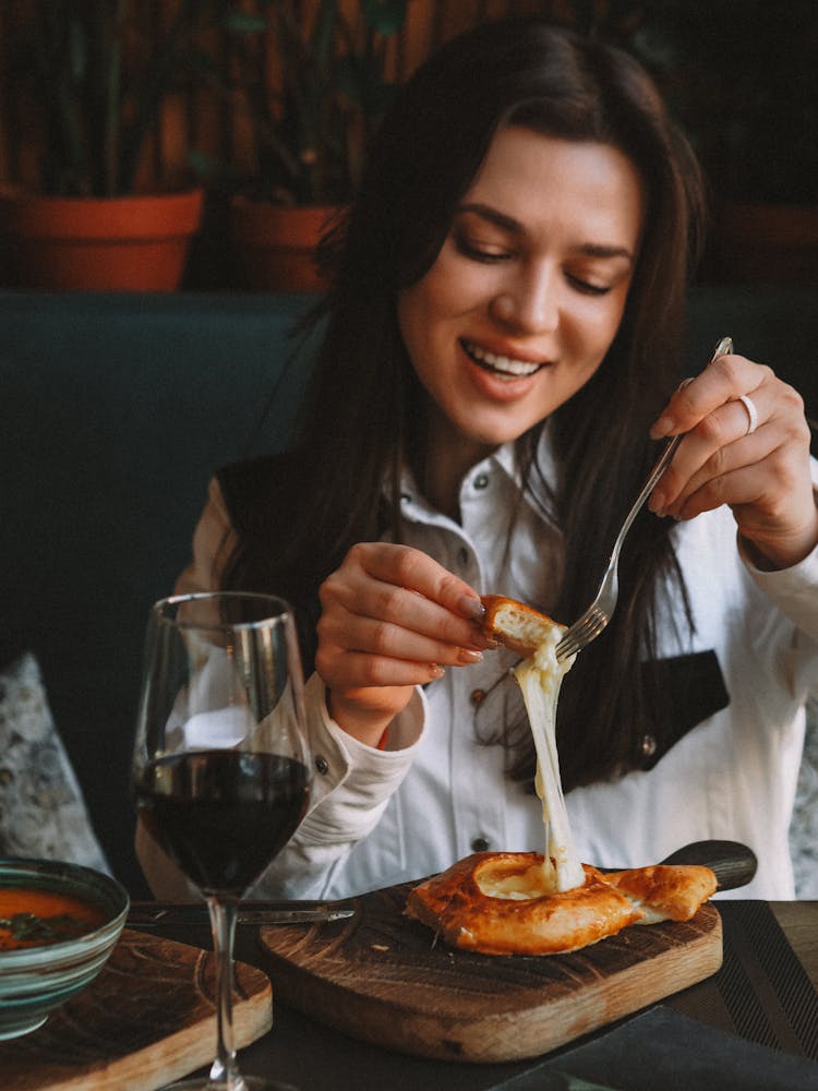 Woman Eating A Bread While Smiling 