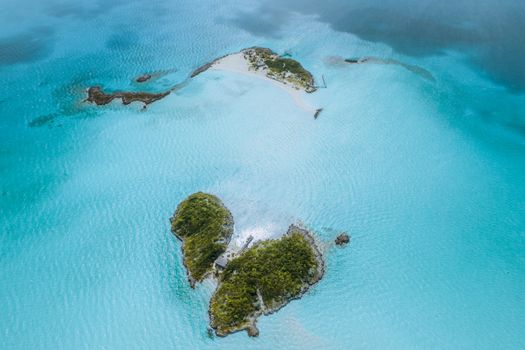 A breathtaking aerial view of lush green islands surrounded by vibrant turquoise ocean water.