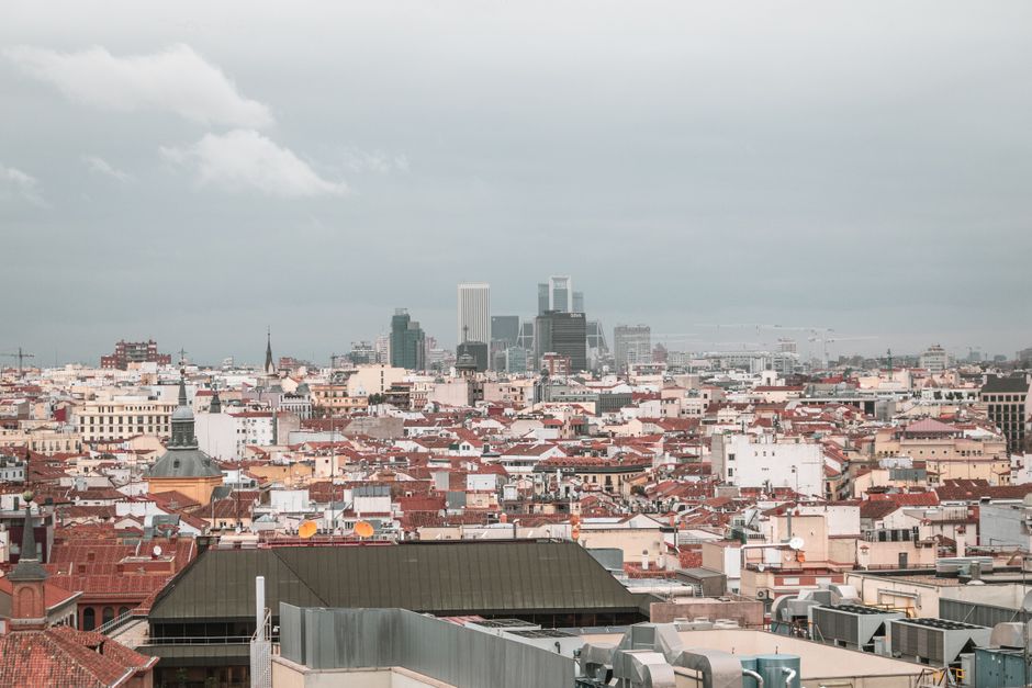 A captivating aerial view of Madrid's skyline showcasing the urban architecture and cityscape under a cloudy sky.