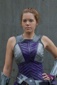Portrait of a woman in a detailed futuristic purple armor costume.