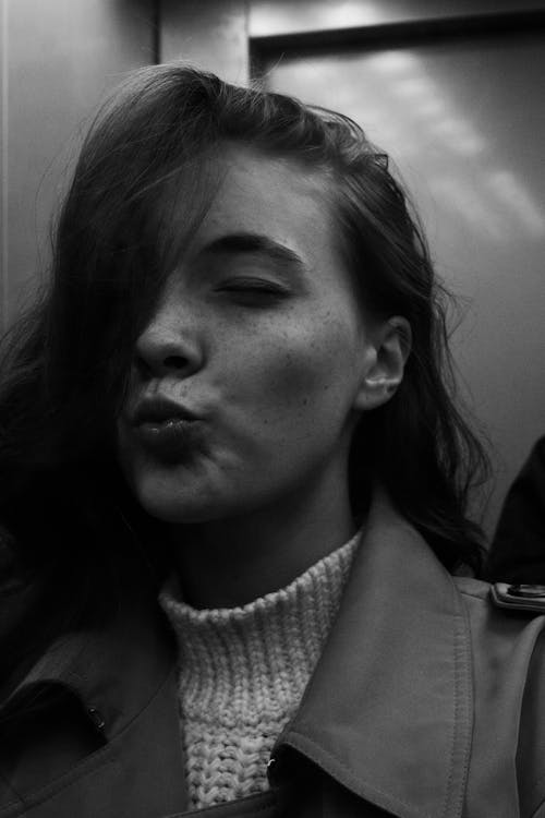 Grayscale Photo of a Woman Pouting Her Lips