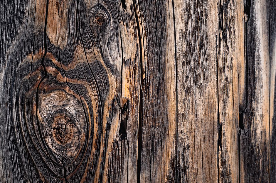Detailed close-up of a weathered wooden surface with distinct grain patterns and natural knots.