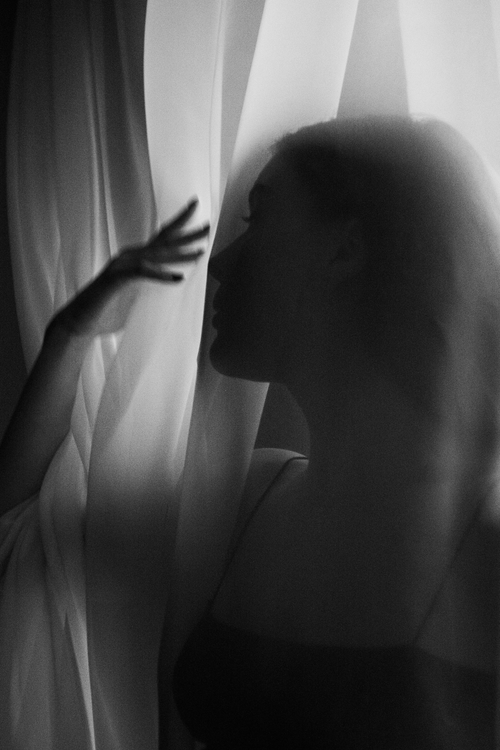 Free Ethereal black and white silhouette of a woman behind a curtain, capturing elegance and mystery. Stock Photo
