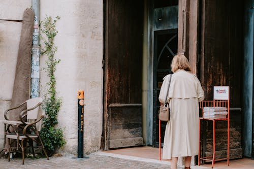 Woman In Trench Coat In Front Of a Building