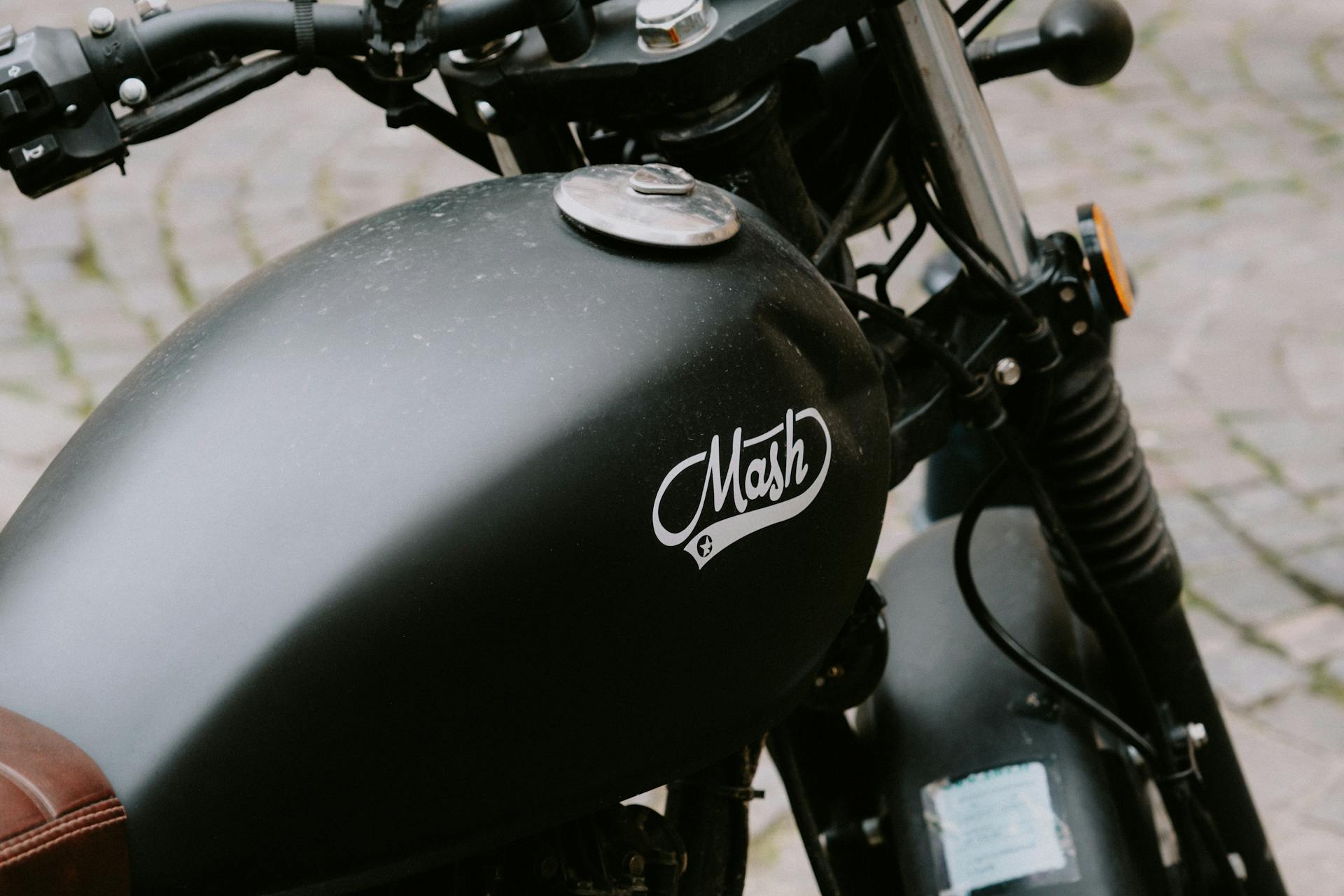 Detailed view of a classic motorcycle fuel tank with a retro design and branding.