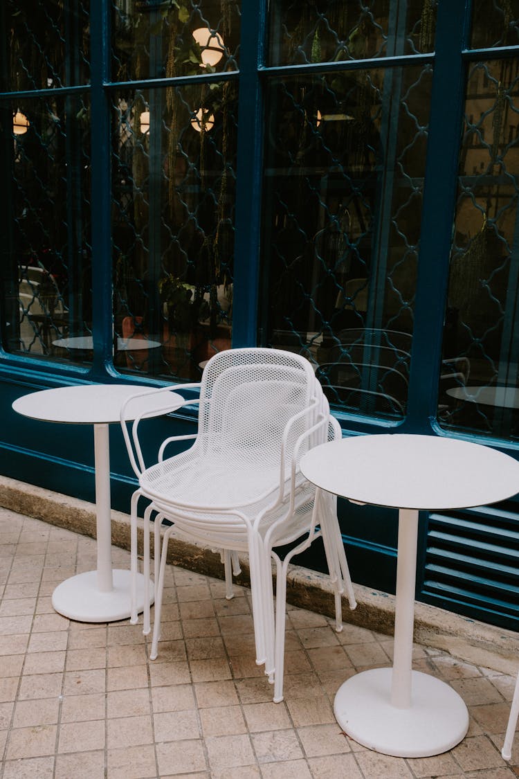 Plastic Chairs Stacked Between Tables