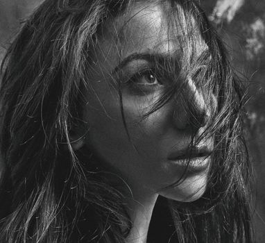 Intense black and white portrait of a woman, capturing emotion and depth.