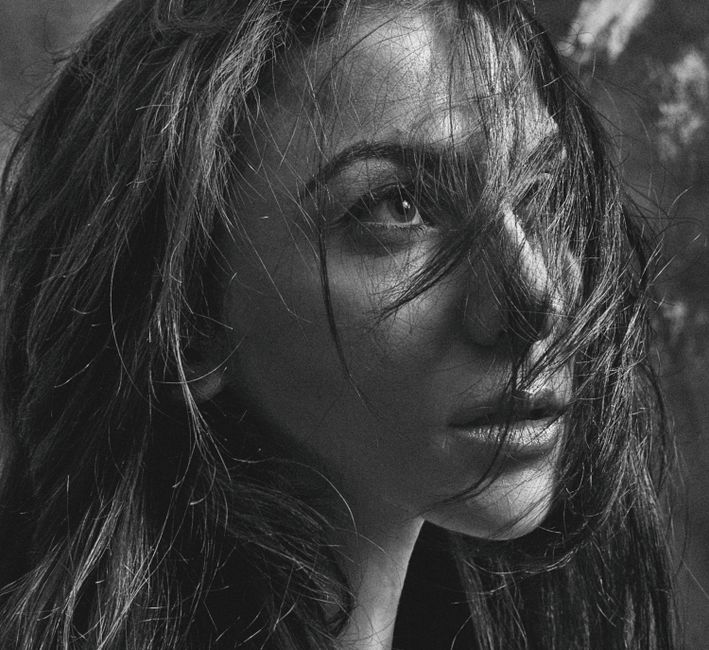Intense black and white portrait of a woman, capturing emotion and depth.