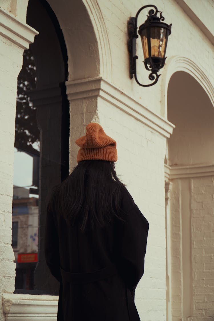 Woman In Orange Hat Walking Past Arcade