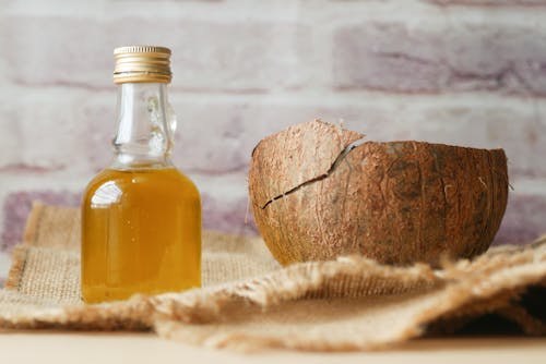 Free Little Bottle with Liquid and a Coconut Shell  Stock Photo