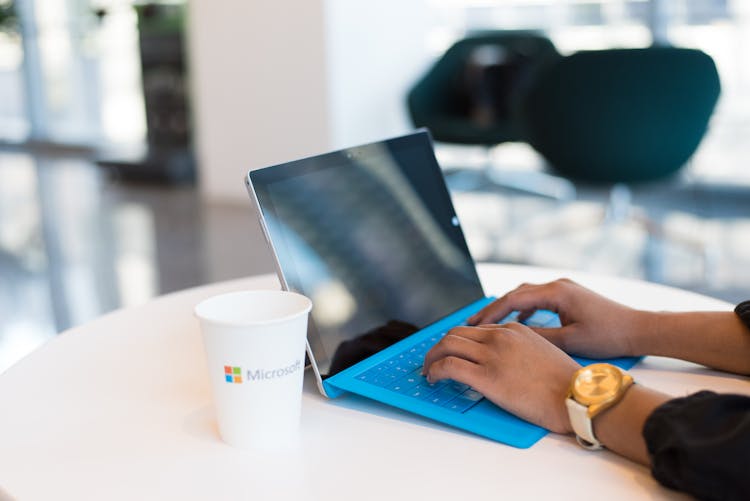 Person Browsing On Black And Blue Laptop Computer