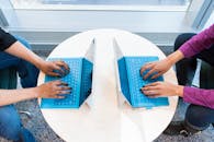 圆桌会议上，两人正使用蓝色笔记本电脑专注地进行团队合作与技术工作