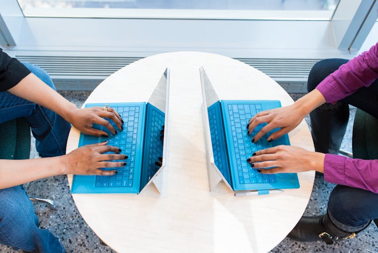 Two People Working On Laptops