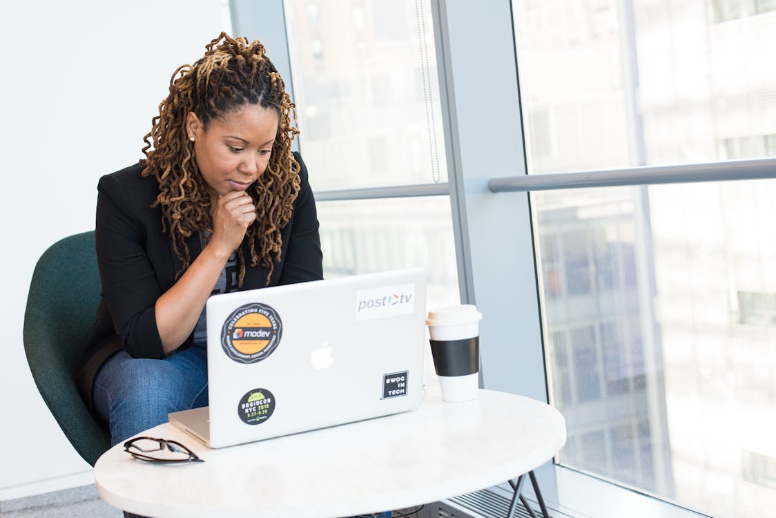 Woman in Black Coat in Front of White Laptop Computer