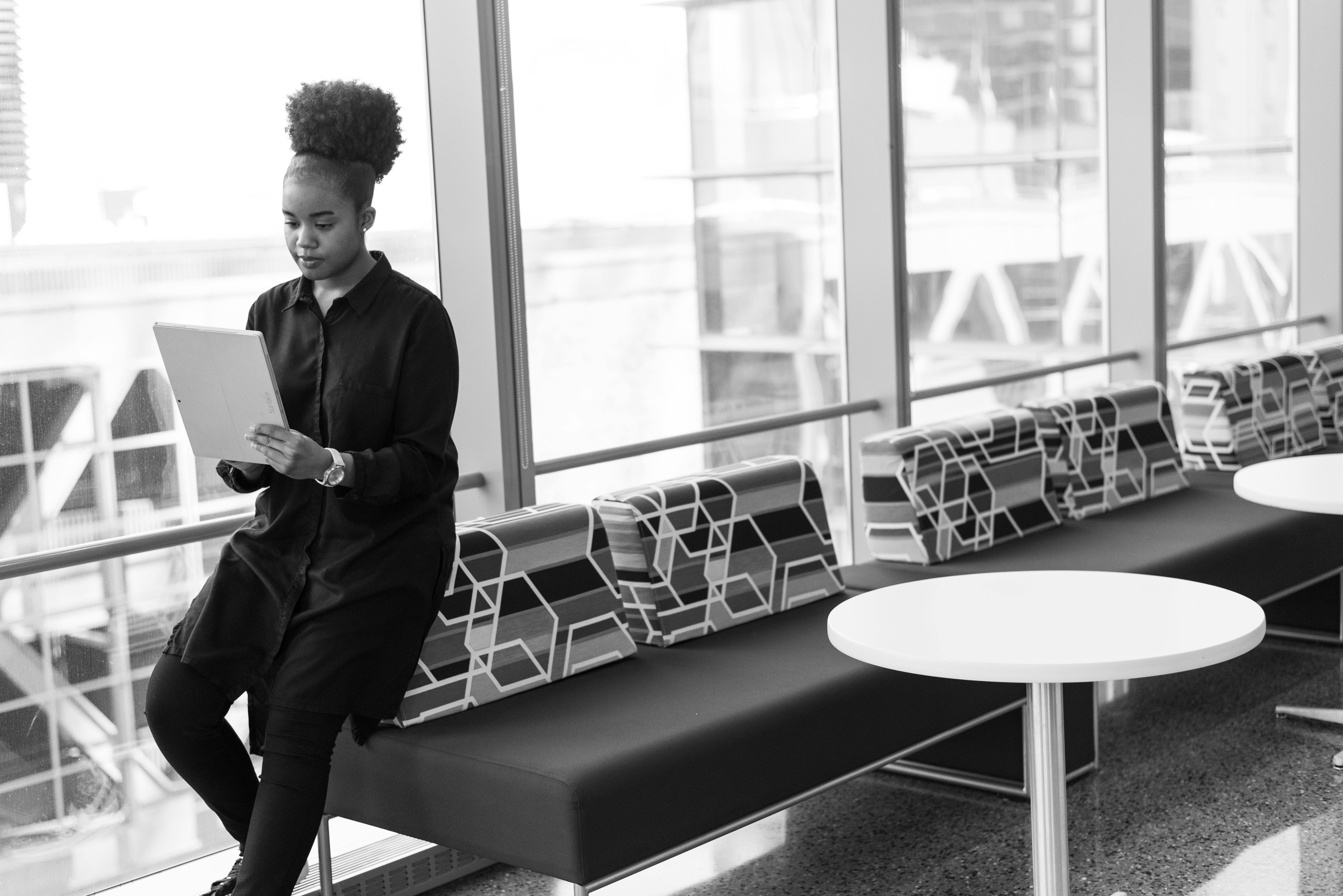 黑白肖像中的现代女性在办公空间使用平板电脑