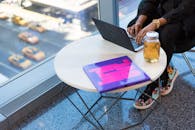 城市工作空间配有笔记本电脑、彩色书籍和城市景观，彰显了现代工作生活方式