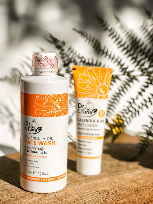 Face Wash and Face Cream on a Wooden Board and Fern in Background